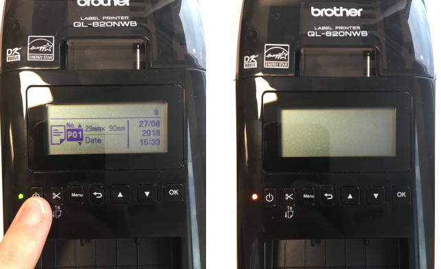 finger pressing on powerbutton at the left side of the Brother bluetooth label printer